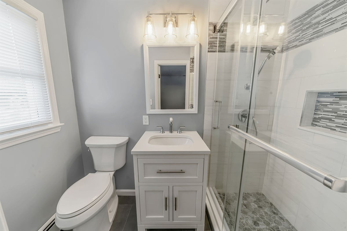 Bathroom renovation by Kuhn Construction in Islip, New York with a vanity and walk-in shower