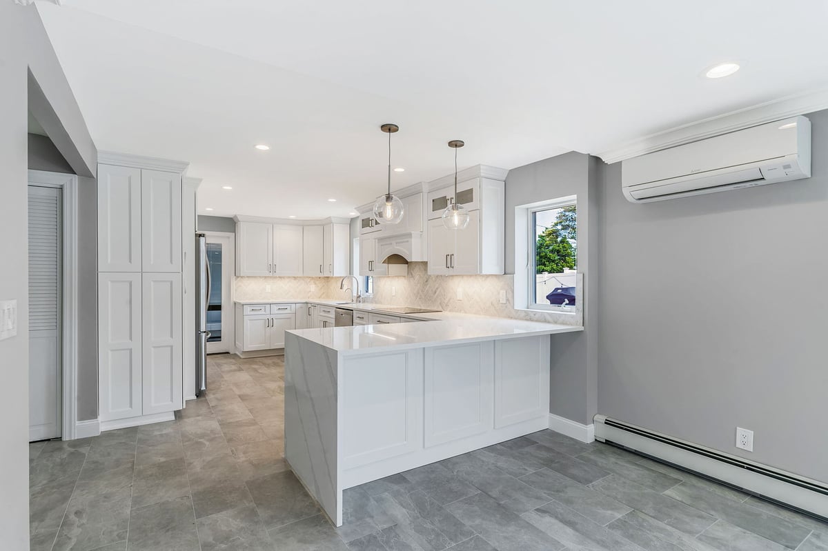 kitchen renovation by Kuhn Construction in Massapequa, New York with white cabinetry and peninsula