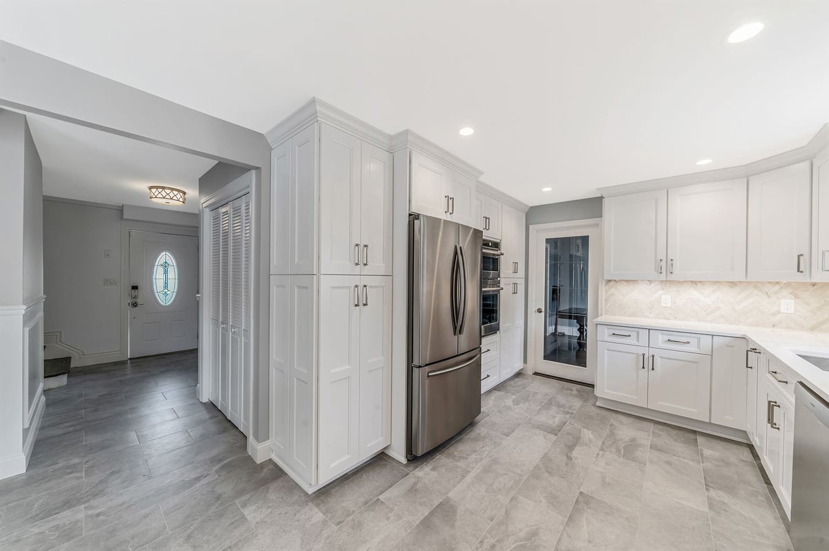 Massapequa kitchen remodel by Kuhn Construction showcasing Fabuwood white cabinetry and stainless steel fridge