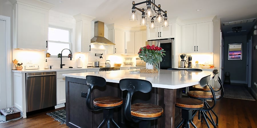 kitchen island with light above and black barstools