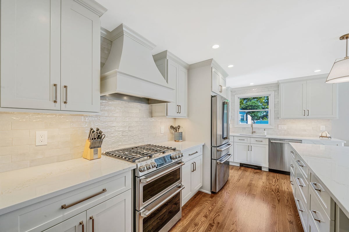 Kitchen remodel with white Fabuwood cabinetry and oak floors by Kuhn Construction in Hicksville, NY