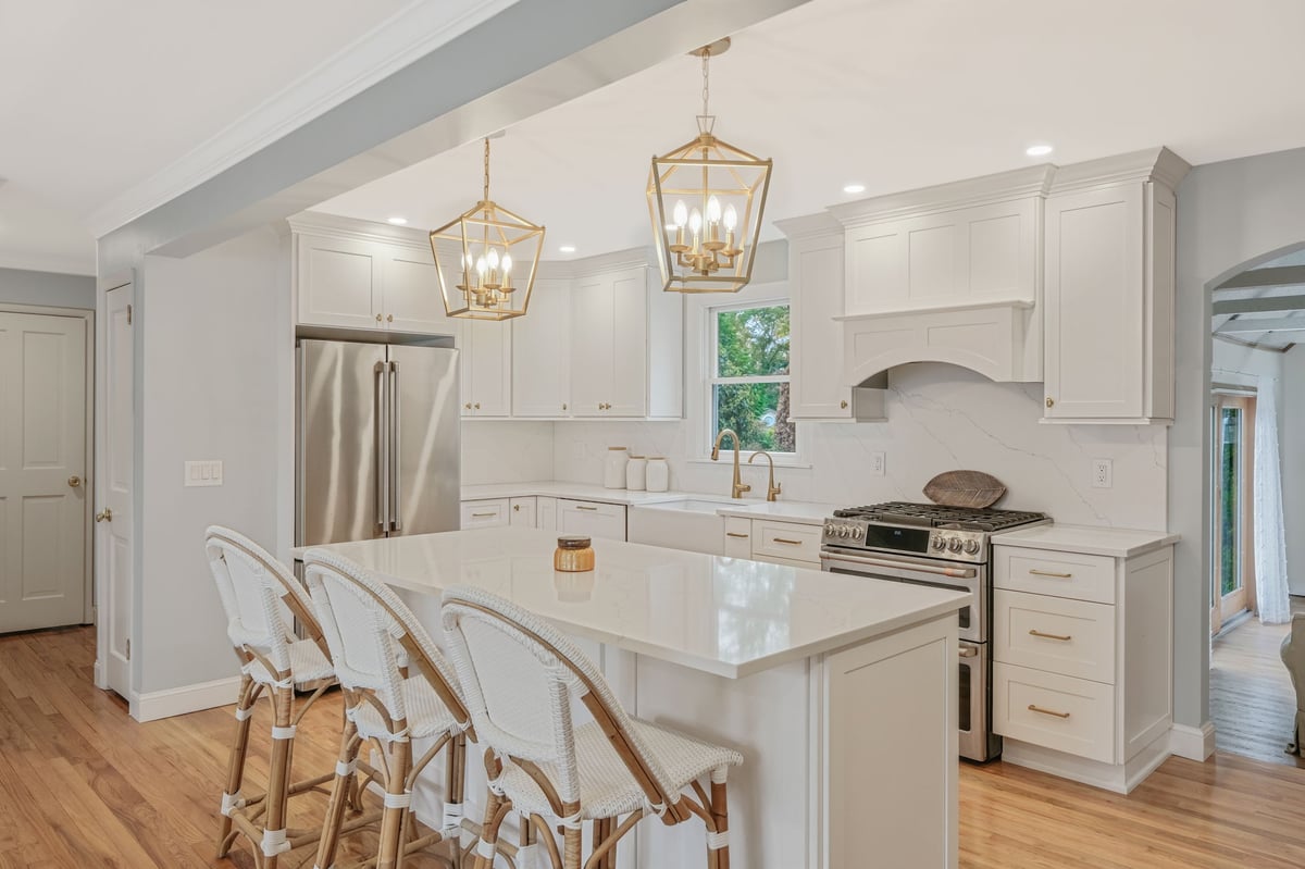 remodeled kitchen with large white island and chairs
