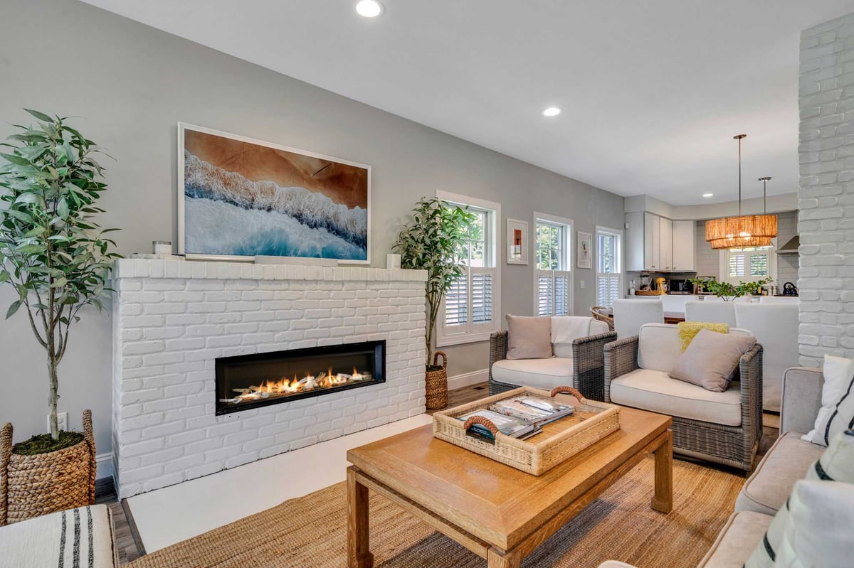 Living room remodel with painted brick fireplace and recessed lighting by Kuhn Construction