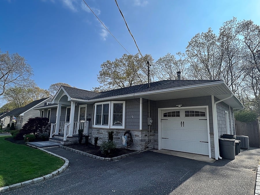 Exterior one-story home remodel with cedar shake siding and stone accents by Kuhn Construction in Patchogue, NY