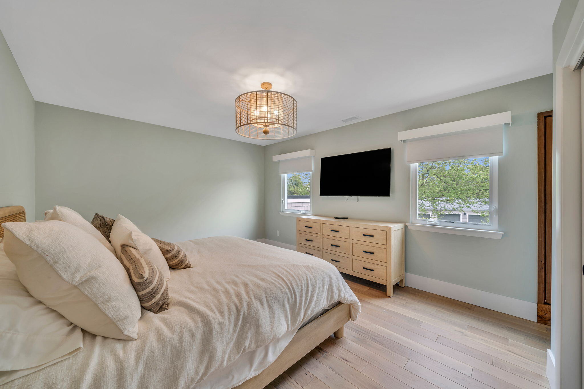 Bedroom in Islip, NY remodel with two windows and TV by Kuhn Construction