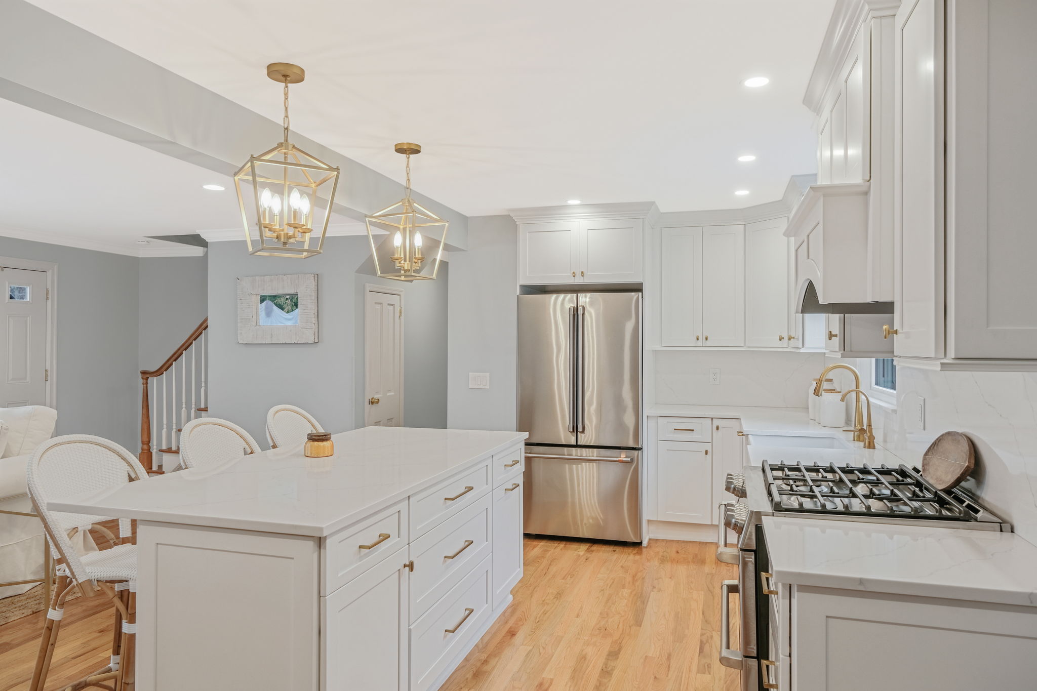 Large kitchen island with two gold pendant lights above in Islip, NY kitchen remodel by Kuhn Construction