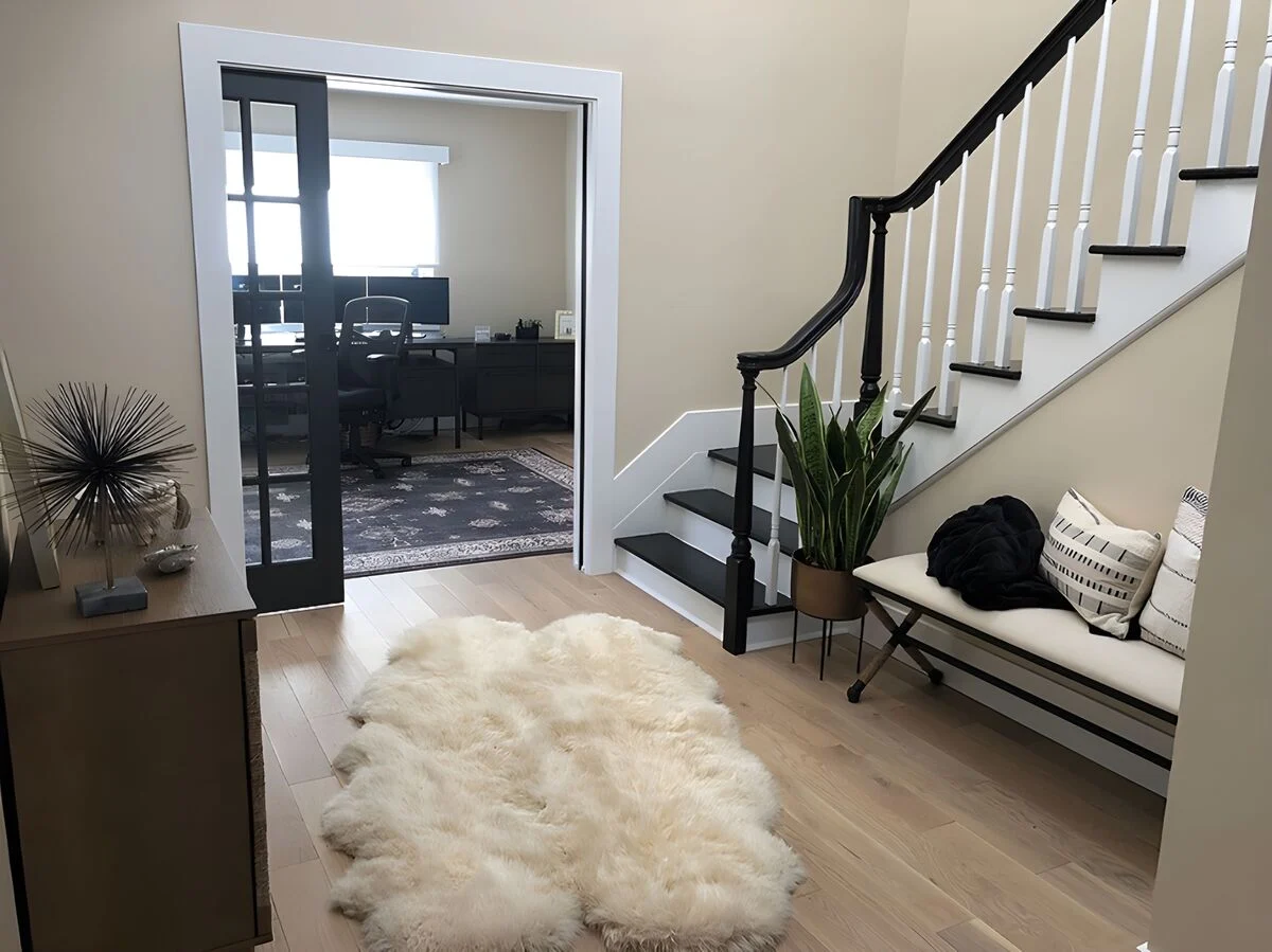 Curved staircase leading to sliding glass doors with home office by Kuhn Construction