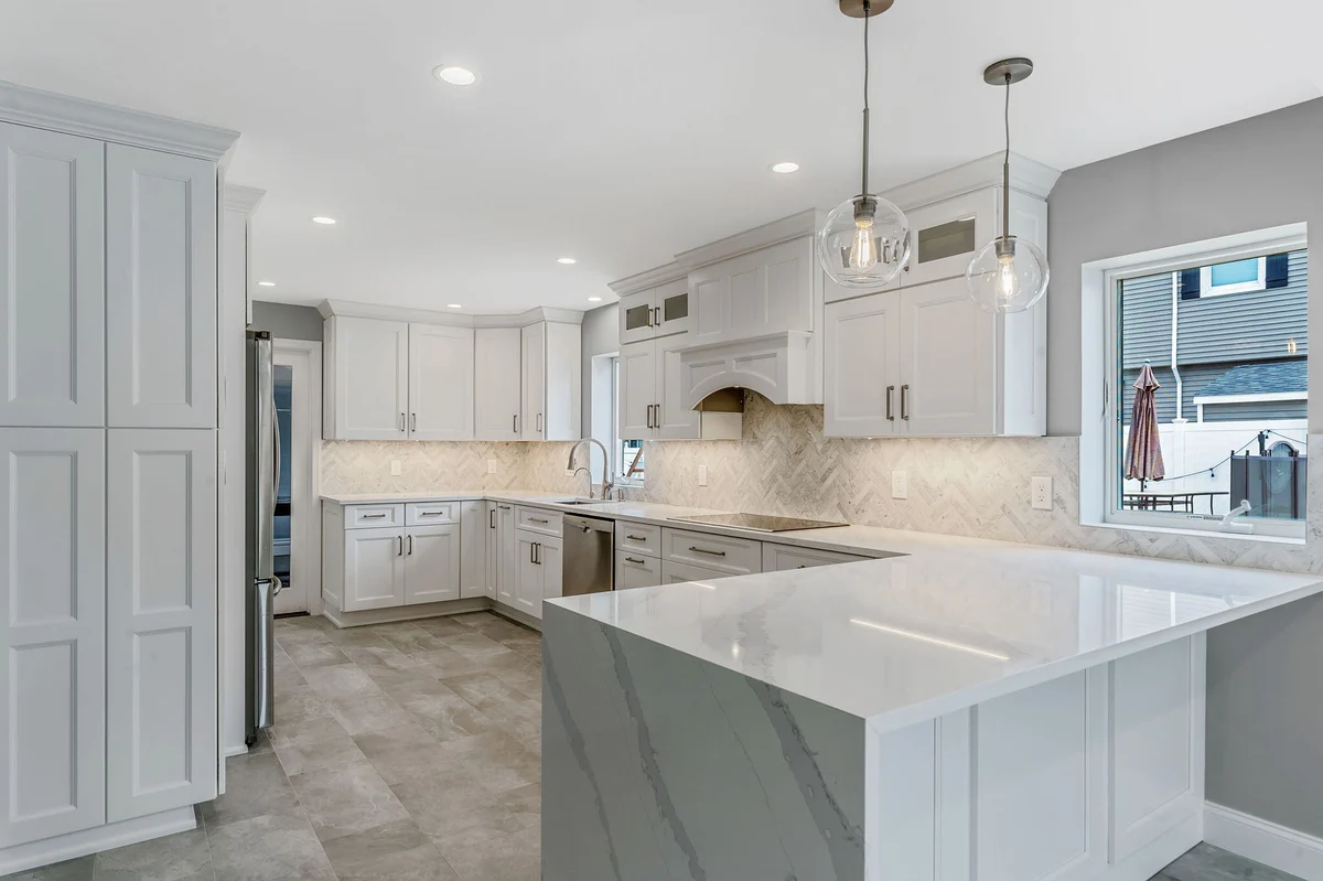 Massapequa kitchen remodel by Kuhn Construction showcasing white cabinets and contemporary lighting (1)