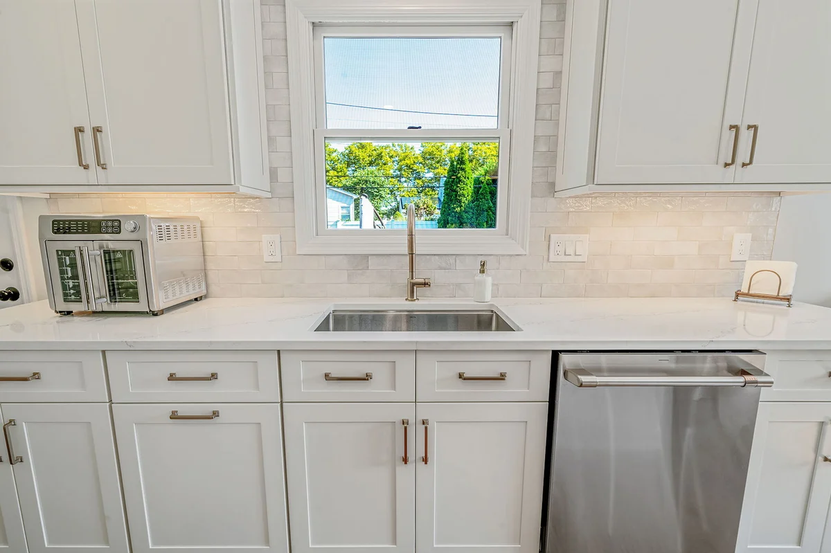 Under mount sink in Hicksville, NY kitchen remodel with window behind by Kuhn Construction