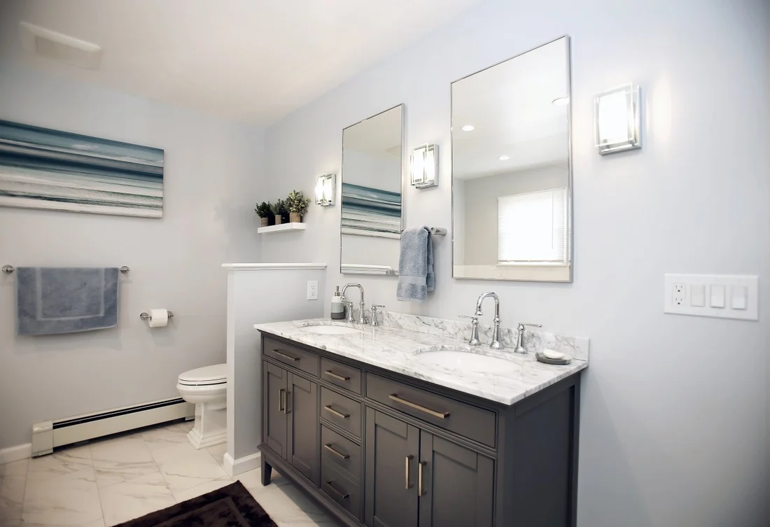 double sinks in a bureau style vanity with marble countertops